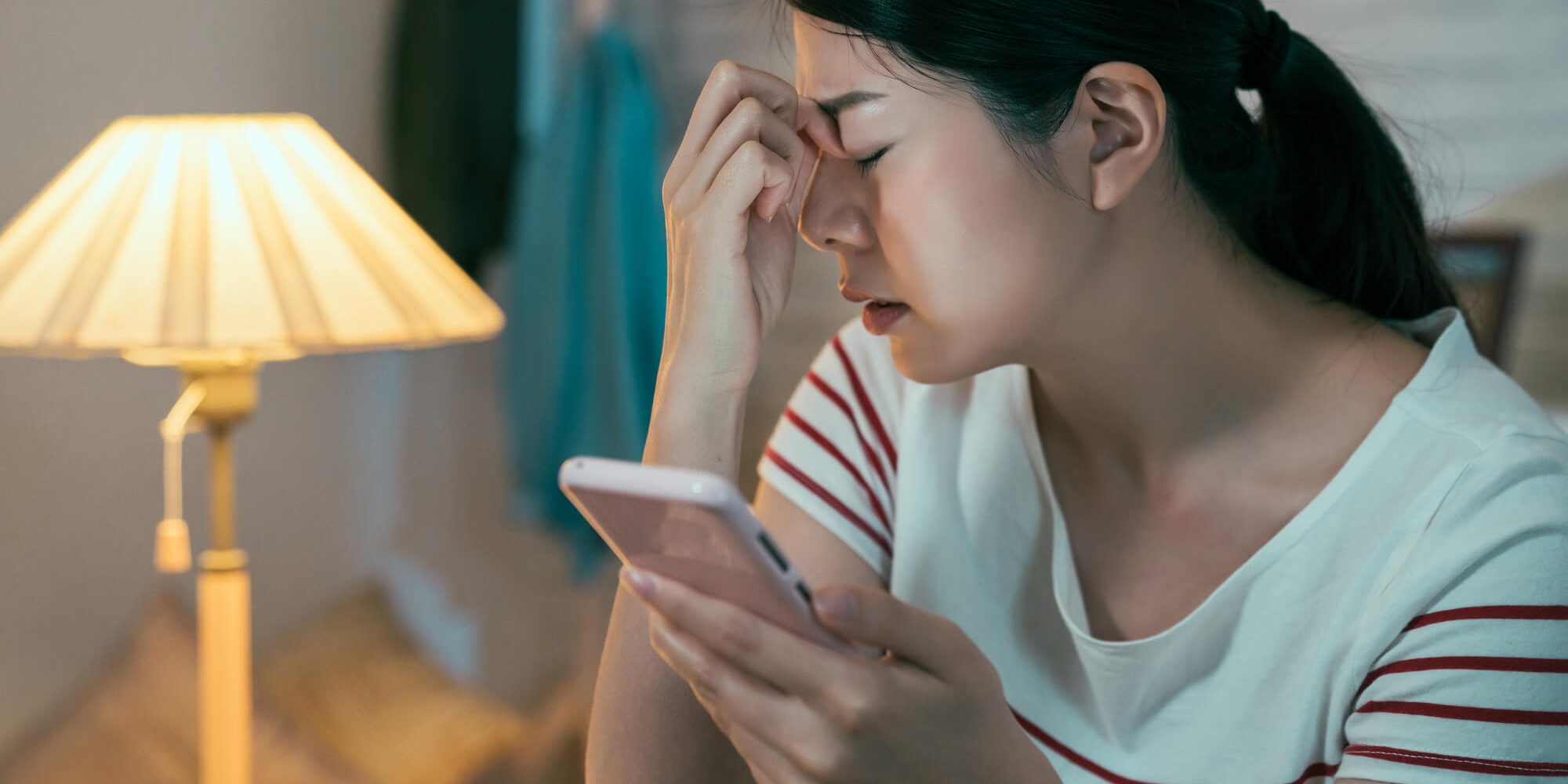 Woman with closed eye phone in hand
