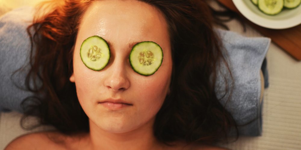 a woman with cucumber slices on eyes