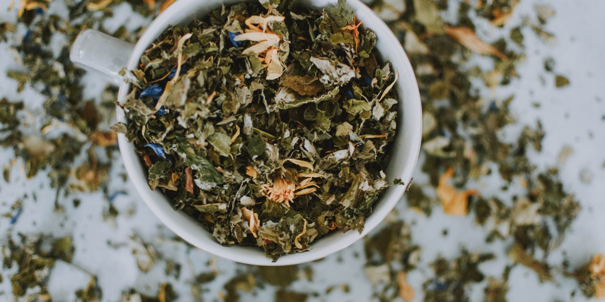 Dry green tea leaves in a cup