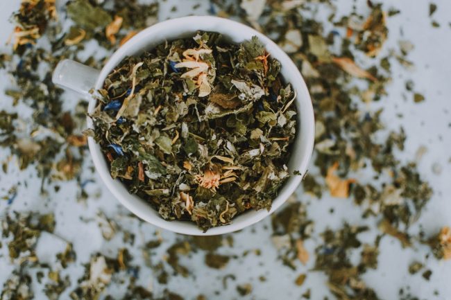 Dry green tea leaves in a cup