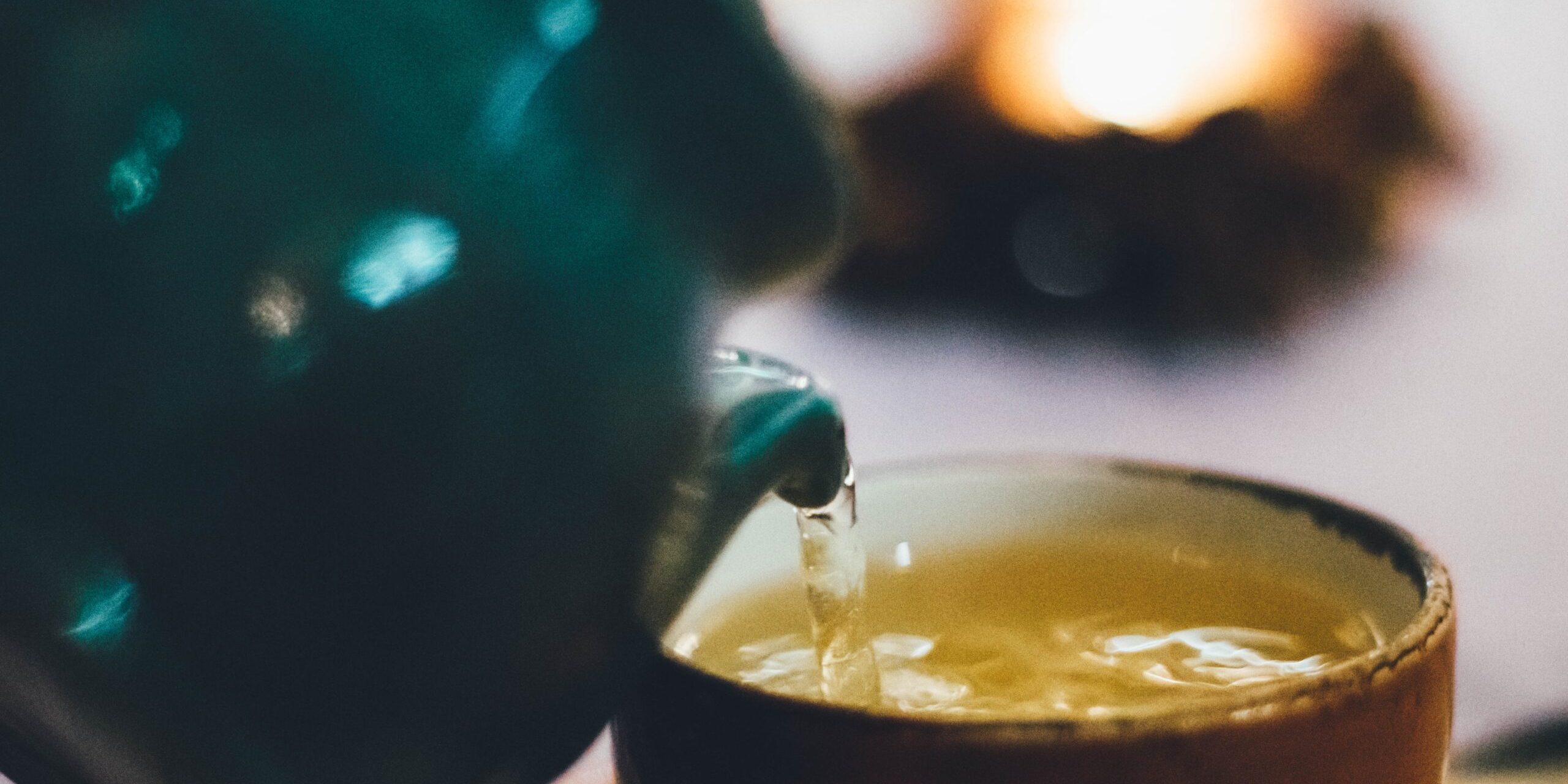 a cattel pouring tea in cup